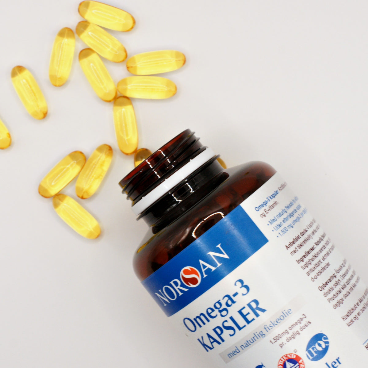Omega-3 kapsler med fiskeolie hældt ud af NORSAN-bøtten