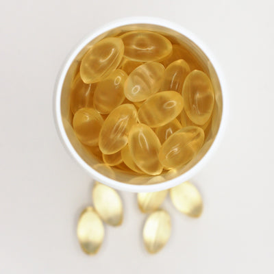 Åben bøtte fyldt med vegan omega-3 kapsler, set oppefra
